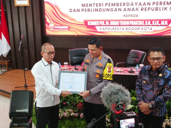 Deputi Perlindungan Anak Kementerian PPPA RI, Nahar saat memberikan penghargaan kepada Kapolresta Bogor Kota, Kombes Pol Bismo Teguh Prakoso, Selasa (9/7). (Yudha Prananda / Jabar Ekspres)