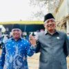 H Sudarsono (kanan) dan H Bambang Hidayah (kiri) saling berjabat tangan di Lembah Pejamben Desa Binangun Kota Banjar usai acara pengibaran bendera merah putih raksasa, Rabu 17 Juli 2024. (Cecep Herdi/Jabar Ekspres)