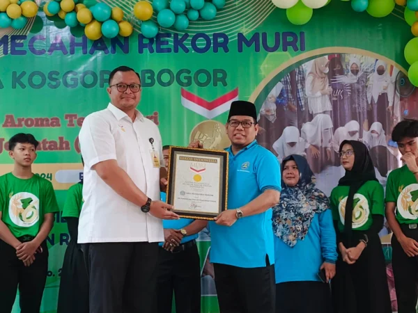 Kepala SMA Kosgoro Kota Bogor, Herman Lasrin (Kanan) saat menerima Piagam Penghargaan Rekor MURI atas karya siswa-siswinya, Rabu (31/7). (Yudha Prananda / Jabar Ekspres)