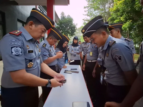 Kalapas Banjar, Amico Balalembang (kiri), memeriksa alat komunikasi berupa telepon pintar milik para petugas di Lapas Banjar, Senin 15 Juli 2024. (Istimewa)
