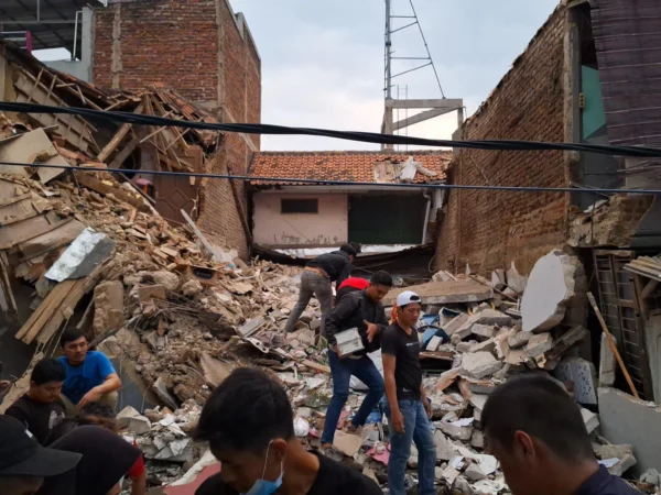 Beberapa warga saat berusaha membantu evakuasi rumah tiga lantai yang roboh di Margahayu, Kabupaten Bandung, Selasa (6/8). Foto Istimewa