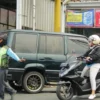 Jukir tengah bertugas di lapak parkiran dan membantu warga mengamankan lajur kendaraan di kawasan Bandung Timur. (Jabar Ekspres)