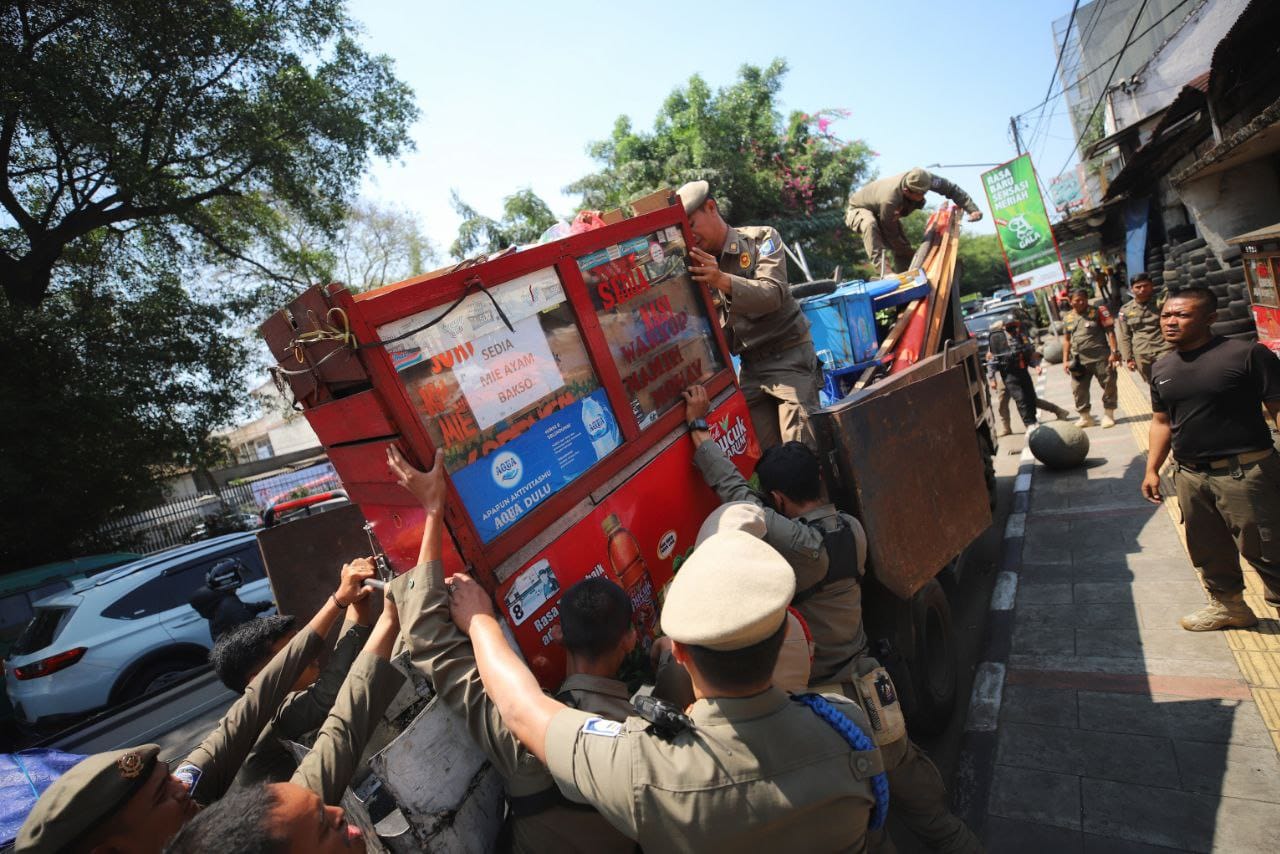 Petugas Satpol PP Kota Bandung saat menertibkan sejumlah kios hingga peralatan dagang di beberapa titik kota, pada Selasa (13/8).