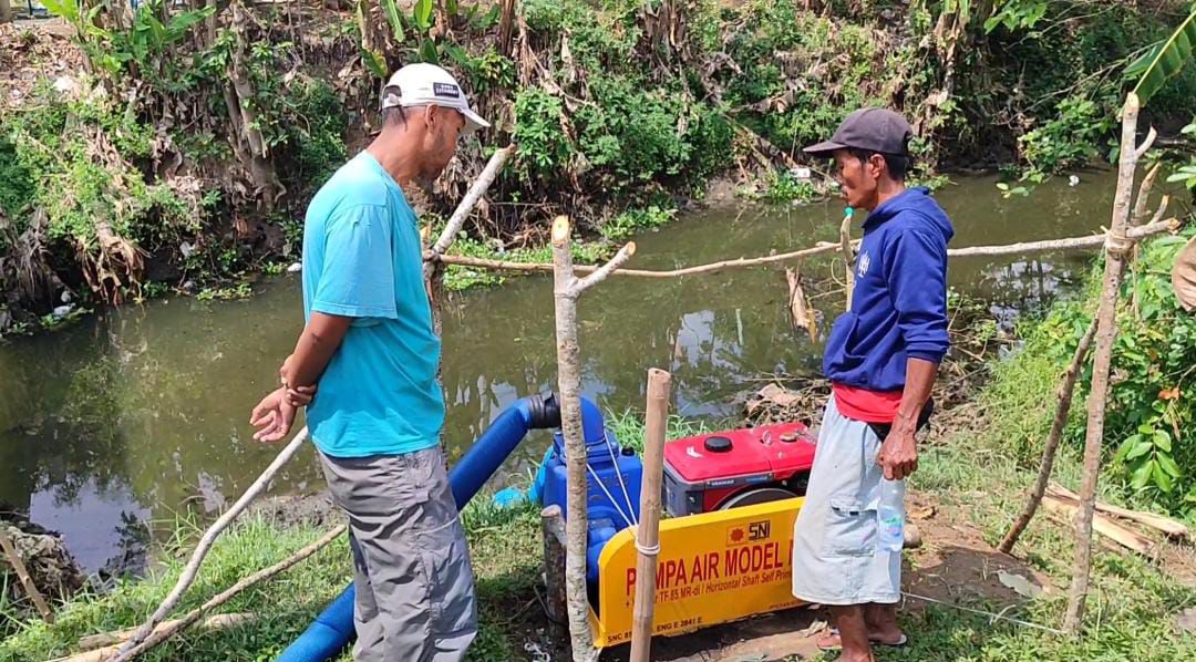 Petani berupaya menyedot air sungai menggunakan pompa air dari Sungai Ciganjeng Kabupaten Pangandaran untuk mengairi sawah mereka yang teranvam gagal panen akibat kekeringan, Selasa 13 Agustus 2024. (Cecep Herdi/Jabar Ekspres)