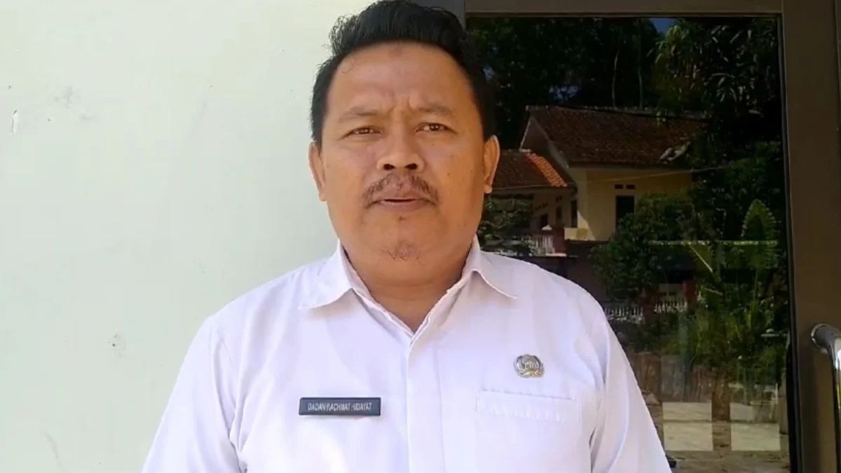 Sekretaris Desa Medanglayang Dadang Rachmat Hidayat saat diwawancara terkait keberadaan papan pengumuman penyitaan aset lahan di wilayanya oleh KPK, Rabu 14 Agustus 2024. (Cecep Herdi/Jabar Ekspres)