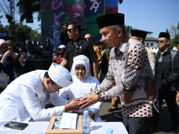 Penjabat Gubernur Jawa Barat Bey Machmudin menjadi saksi nikah pada kegiatan nikah massal dalam rangkaian West Java Festival 2024 di kawasan Gedung Sate, Kota Bandung, Sabtu (24/8/2024).(Foto: Rizal FS/Biro Adpim Jabar)