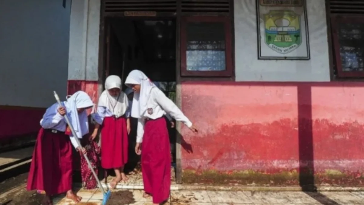 Sejumlah siswa SD membersihkan lumpur pasca banjir di Muaro Jambi. (foto/ANTARA)