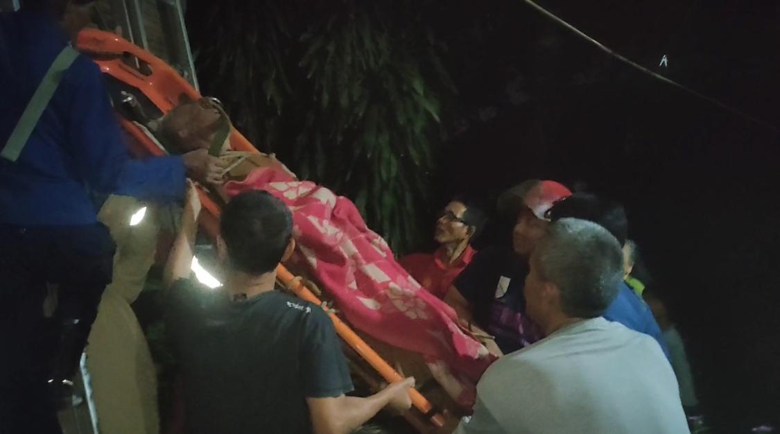 Toto (76) saat dievakuasi oleh warga bersama Dinas Pemadam Kebakaran dan Penyelamatan Kabupaten Bandung, setelah terjebak di atap rumahnya, di Cileunyi, Kabupaten Bandung Foto: Istimewa