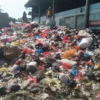 Seorang pria tengah memilah sampah yang menumpuk di TPS sementara Pasar Sehat Cileunyi, Kabupaten Bandung. (Yanuar/Jabar Ekspres)