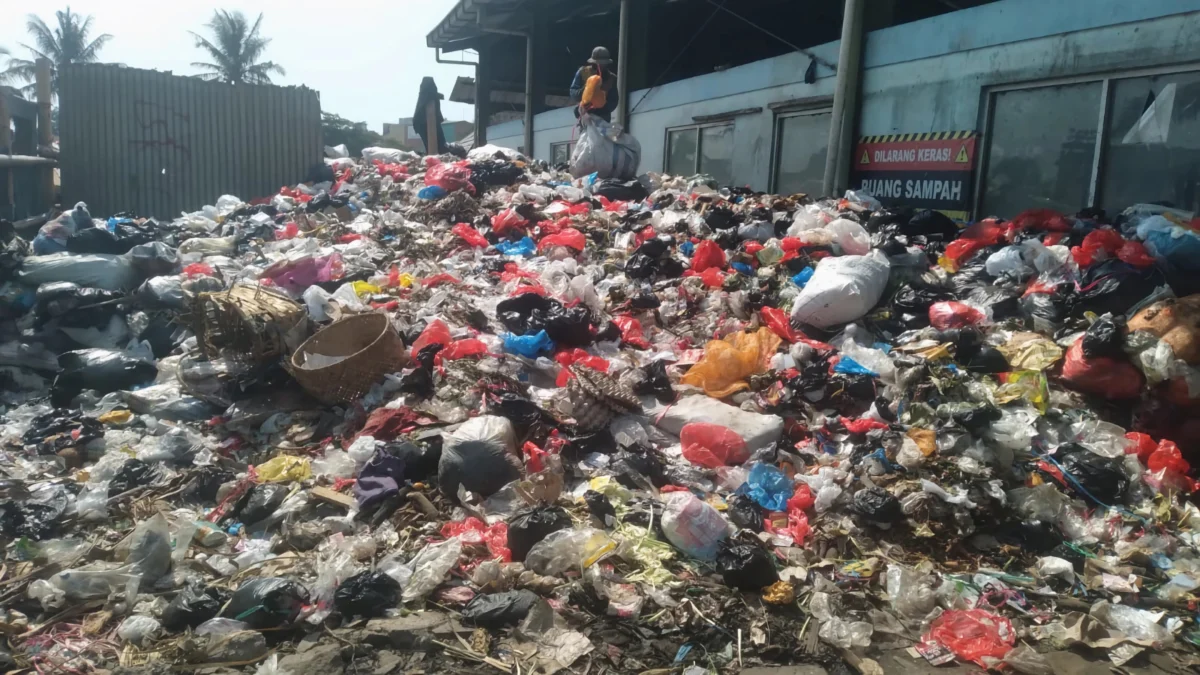 Seorang pria tengah memilah sampah yang menumpuk di TPS sementara Pasar Sehat Cileunyi, Kabupaten Bandung. (Yanuar/Jabar Ekspres)