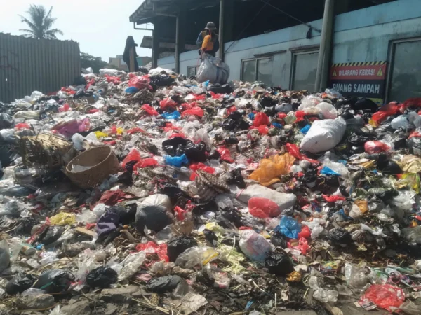 Seorang pria tengah memilah sampah yang menumpuk di TPS sementara Pasar Sehat Cileunyi, Kabupaten Bandung. (Yanuar/Jabar Ekspres)