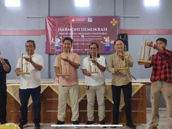 Perwakilan dari KPU Ciamis, IJTI Galuh Raya, Desa Panyingkiran, dan pengrajin angklung membunyikan angklung bersama-sama sebelum sosialisasi Pilkada serentak dimulai, di gor Desa Panyingkiran, Kabupaten Ciamis, Senin 9 September 2024. (Cecep Herdi/Jabar Ekspres)