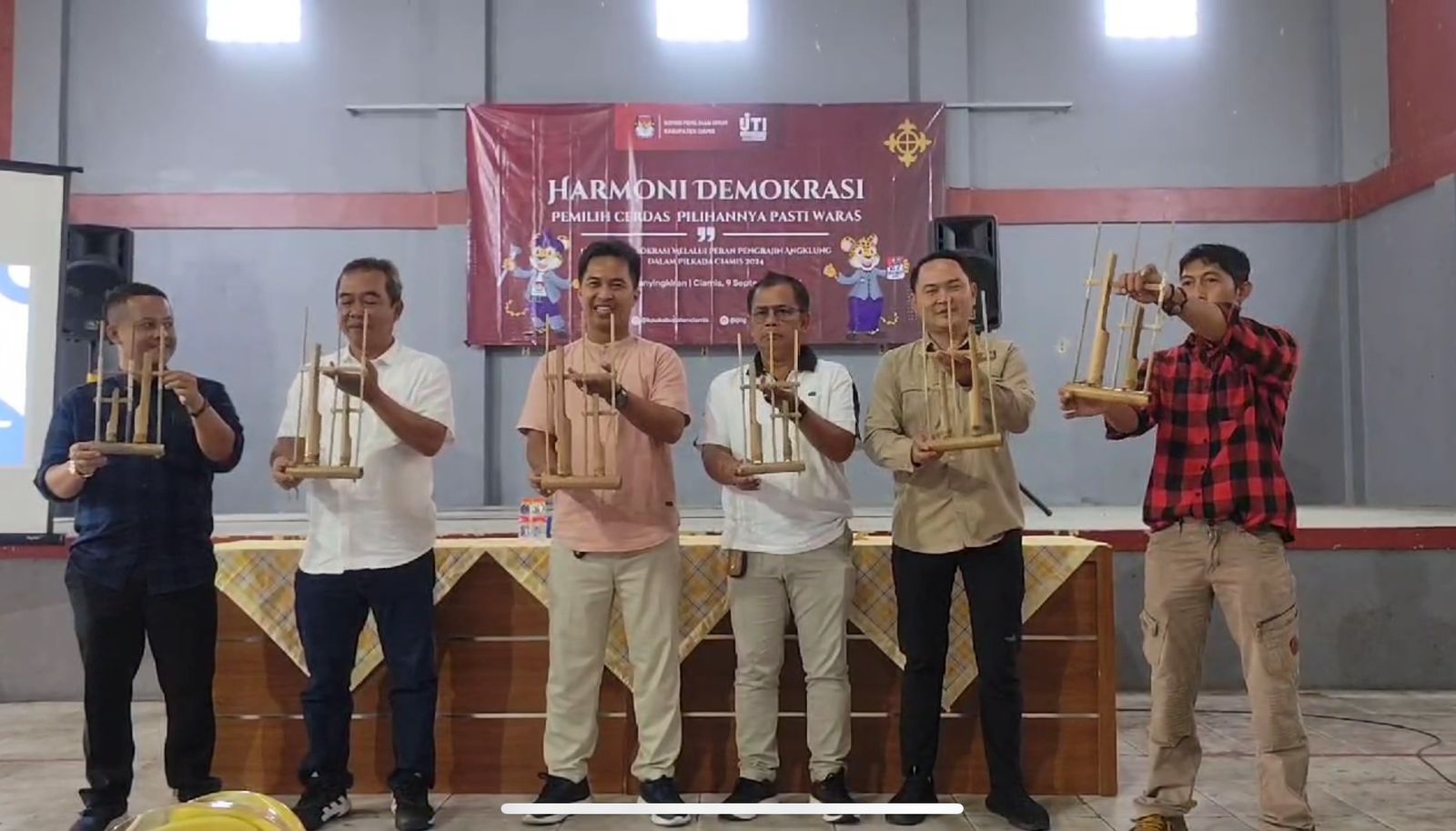 Perwakilan dari KPU Ciamis, IJTI Galuh Raya, Desa Panyingkiran, dan pengrajin angklung membunyikan angklung bersama-sama sebelum sosialisasi Pilkada serentak dimulai, di gor Desa Panyingkiran, Kabupaten Ciamis, Senin 9 September 2024. (Cecep Herdi/Jabar Ekspres)