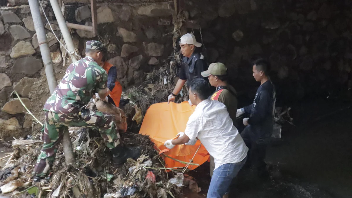 Petugas saat mengevakuasi mayat pria yang ditemukan mengambang di tumpukan sampah Sungai Cipadaulun, Majalaya. Foto Istimewa