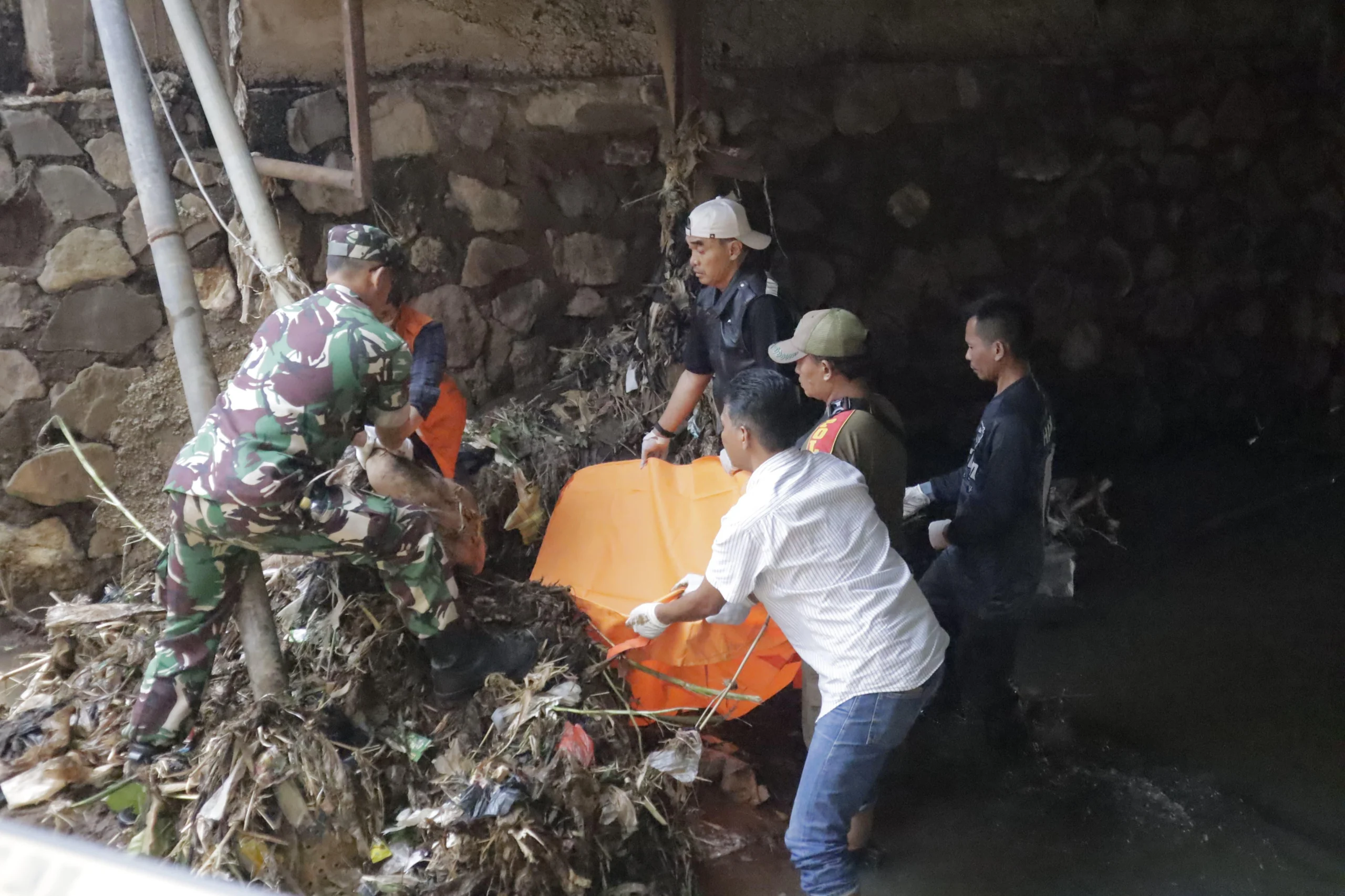 Petugas saat mengevakuasi mayat pria yang ditemukan mengambang di tumpukan sampah Sungai Cipadaulun, Majalaya. Foto Istimewa