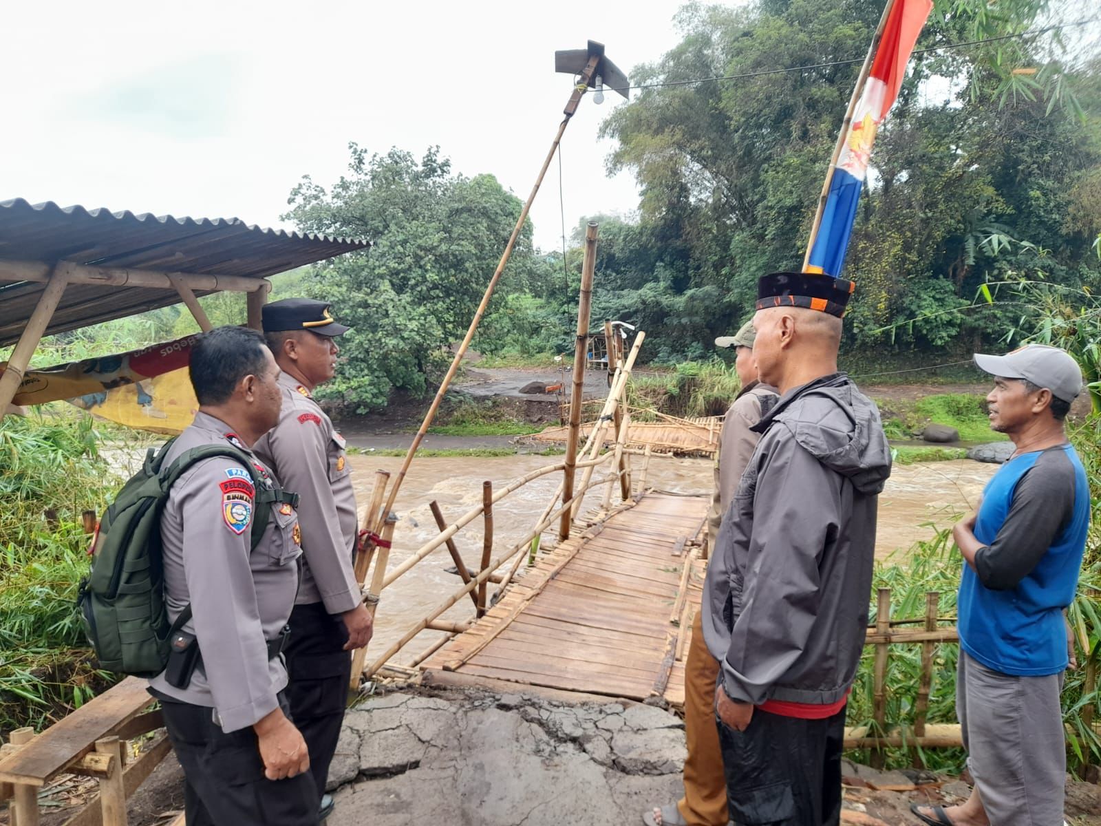 PIhak kepolisian saat mengecek kondisi jembatan yang menghubungkan dua desa Pacet dan Majalaya terputus akibat derasnya debit air anak sungai citarum. Foto Istimewa