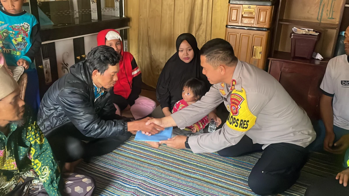 Wakapolresta Bandung AKBP Maruly Pardede saat memberikan santunan kepada kedua orang tua Fauzan yang meninggal akibat gempa di Desa Cikembang, Kertasari, Kabupaten Bandung. Foto Agi