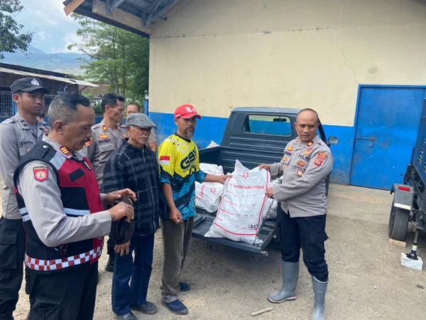 Kapolsek Pangalengan AKP Edi Pramana saat memberikan bantuan ayam beku olahan kepada warga Kecamatan Pangalengan yang terdampak. Foto Istimewa