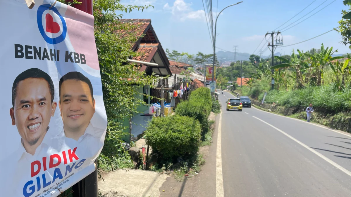 Alat peraga sosialisasi salah satu Paslon Pilkada 2024 di Bandung Barat ditempel di tiang listrik. Senin (30/9). Dok Jabar Ekspres