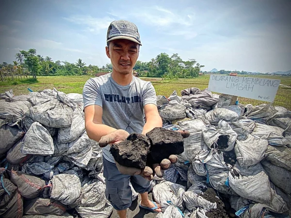 Salah seorang warga Kampung Rongga, Desa/Kecamatan Cihampelas, Bandung Barat saat memperlihatkan limbah batu bara yang dibuang sembarangan. Kamis (17/10). Dok Jabar Ekspres