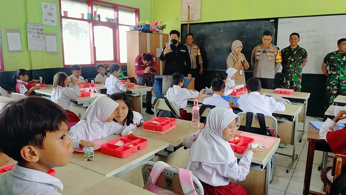 Jajaran Polres Cimahi dan Kodim 0609 Cimahi saat memberikan makan siang gratis di SD Negeri 3 Cipatat, Bandung Barat. Kamis (24/10). Dok Jabar Ekspres