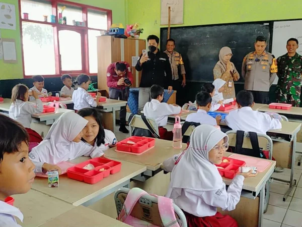 Jajaran Polres Cimahi dan Kodim 0609 Cimahi saat memberikan makan siang gratis di SD Negeri 3 Cipatat, Bandung Barat. Kamis (24/10). Dok Jabar Ekspres