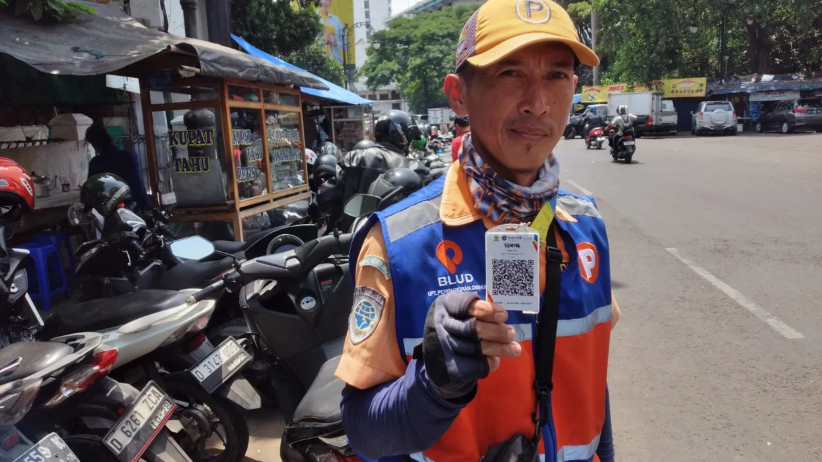 Petugas parkir yang dilengkapi barcode QRIS di Jalan ABC Kota Bandung.