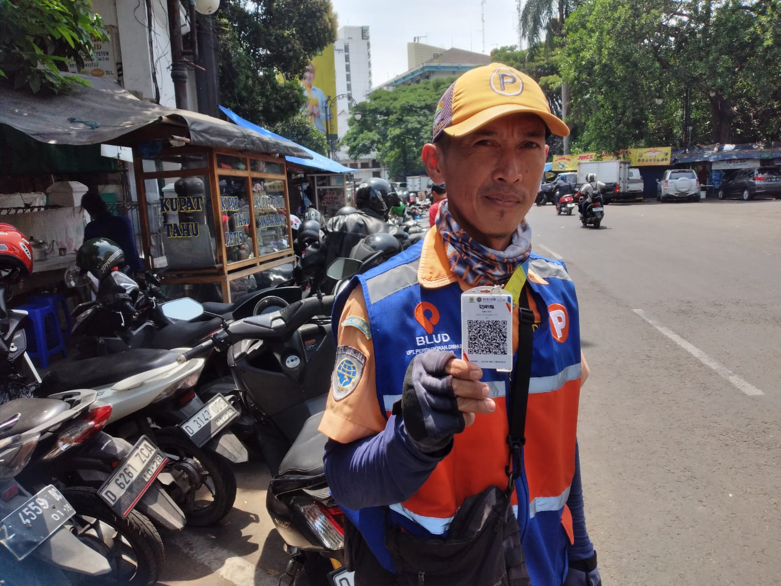 Petugas parkir yang dilengkapi barcode QRIS di Jalan ABC Kota Bandung.