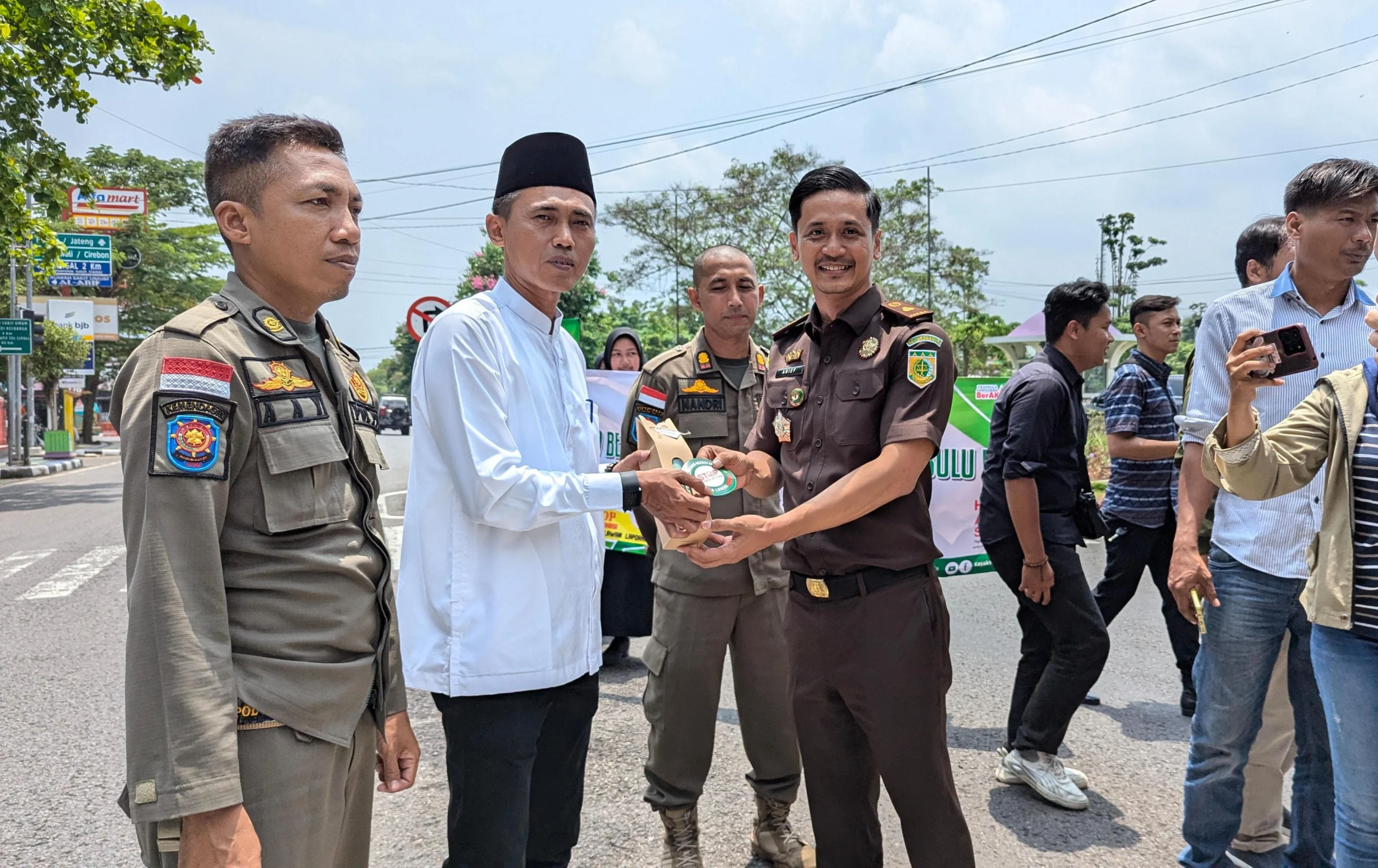 Kasi Intel Kejaksaan Negeri Ciamis Arief Gunadi memberikan bingkisan dan atiker anti korupsi kepada salah satu warga Ciamis, di sekitar Alun Alum Ciamis, Jawa Barat, Selasa 22 Oktober 2024. (Cecep Herdi/Jabar Ekspres)