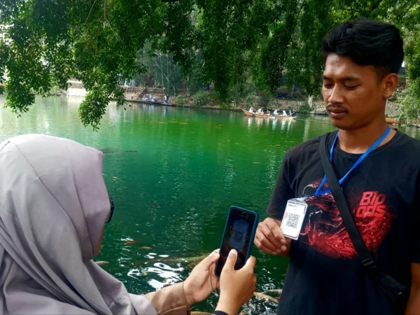 DIGITAL : Salah satu wisatawan saat membayar wahana perahu memanfaatkan QRIS di Telaga Biru Cicerem, Minggu (20/10). (Hendrik Muchlison)