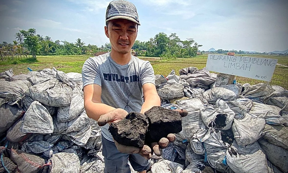 Salah seorang warga Kampung Rongga, Desa/Kecamatan Cihampelas, Bandung Barat, saat memperlihatkan limbah B3 jenis batu bara. Dok Jabar Ekspres