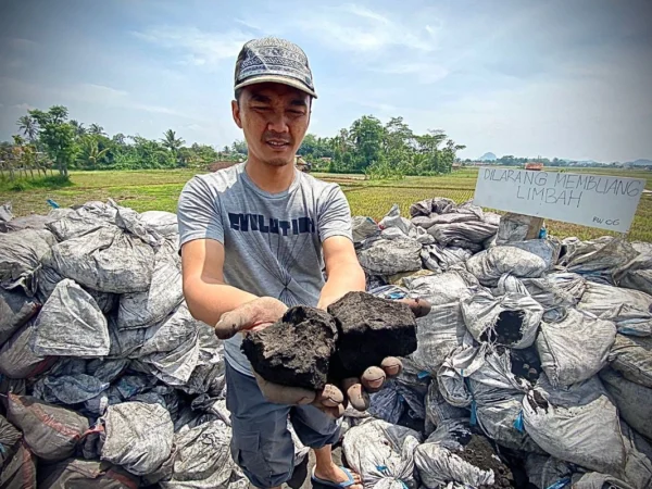 Salah seorang warga Kampung Rongga, Desa/Kecamatan Cihampelas, Bandung Barat, saat memperlihatkan limbah B3 jenis batu bara. Dok Jabar Ekspres