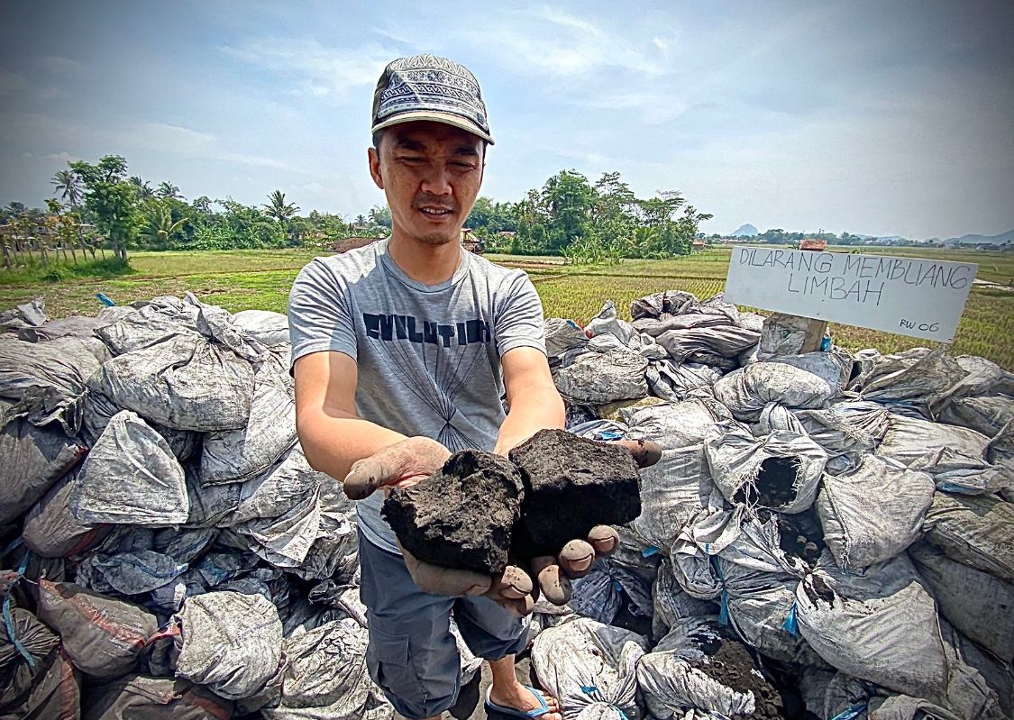 Salah seorang warga Kampung Rongga, Desa/Kecamatan Cihampelas, Bandung Barat, saat memperlihatkan limbah B3 jenis batu bara. Dok Jabar Ekspres