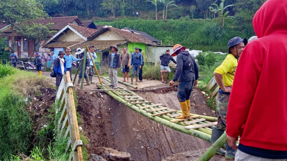 Warga gotong-royong bangun akses sementara akibat jembatan penghubung Desa Tarumajaya dengan Desa Cikembang, di wilayah Kecamatan Kertasari, Kabupaten Bandung ambruk.