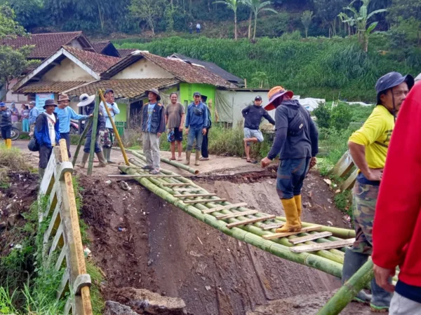 Warga gotong-royong bangun akses sementara akibat jembatan penghubung Desa Tarumajaya dengan Desa Cikembang, di wilayah Kecamatan Kertasari, Kabupaten Bandung ambruk.