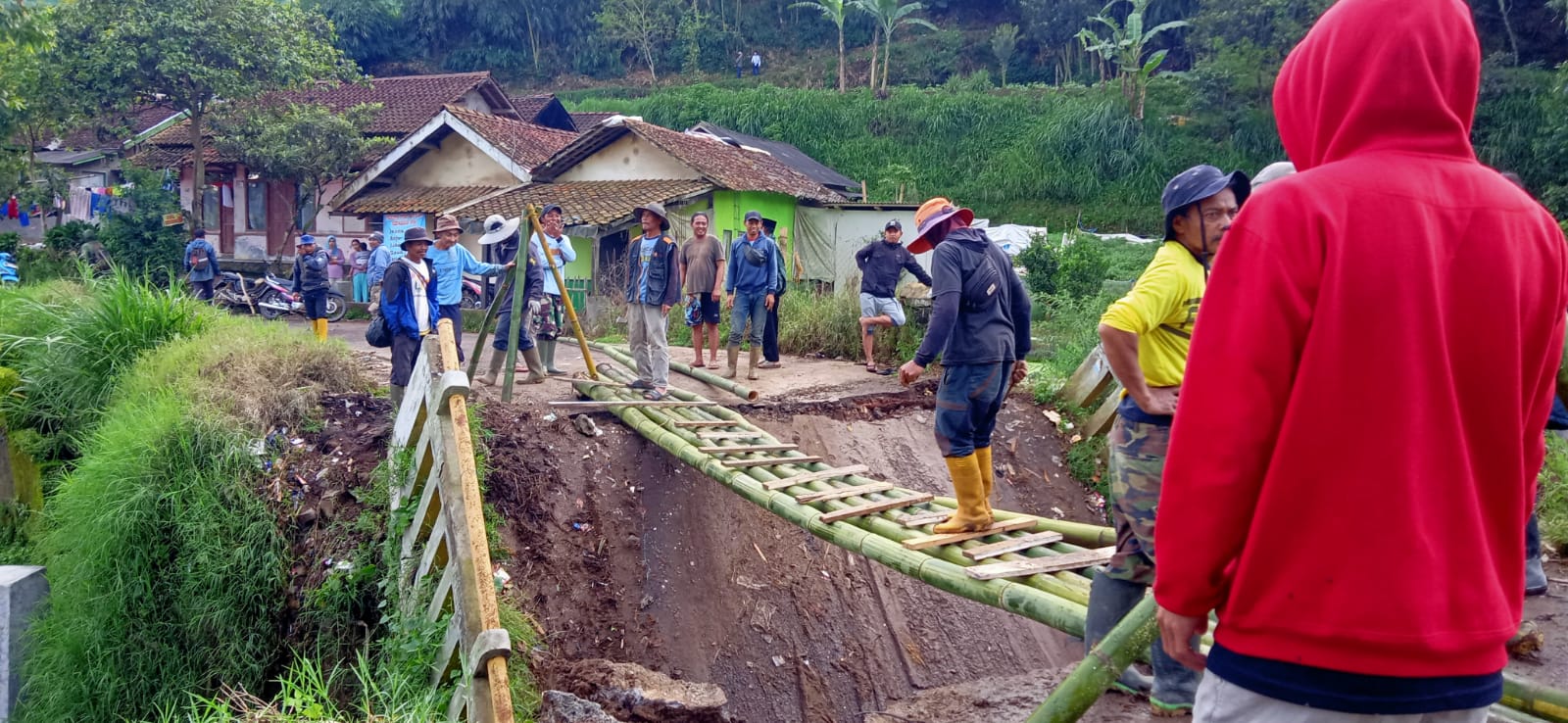 Warga gotong-royong bangun akses sementara akibat jembatan penghubung Desa Tarumajaya dengan Desa Cikembang, di wilayah Kecamatan Kertasari, Kabupaten Bandung ambruk.