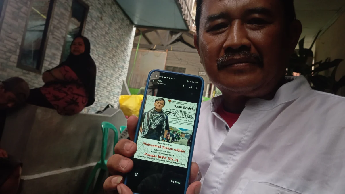 Sudrajat (53), ayah kandung dari Reihan saat menunjukkan foto terbaik mendiang anaknya di rumah duka, Kecamatan Pajajaran, Kelurahan Cicendo, Kota Bandung, pada Jumat (29/11) sore. (NIZAR/JABAR EKSPRES)