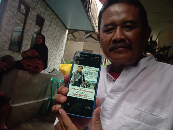 Sudrajat (53), ayah kandung dari Reihan saat menunjukkan foto terbaik mendiang anaknya di rumah duka, Kecamatan Pajajaran, Kelurahan Cicendo, Kota Bandung, pada Jumat (29/11) sore. (NIZAR/JABAR EKSPRES)