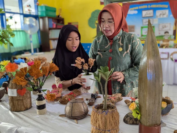 Kepala UPTD SD Negeri 2 Balokang Kota Banjar, Ai Aan Hasanah SAg bersama siswanya yang berhasil membuat hiasan vas bunga daei sabut kelapa, dalam gelar karya di SD Negeri 2 Balokang, Sabtu 30 November 2024. (Cecep Herdi/Jabar Ekspres)