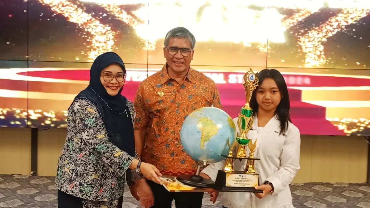 Pj Wali Kota Cimahi, Dicky Saromi bersama Kepala DP3AP2KB, Fitriani Manan saat Memberikan Piala pada Siswi Juara Sekolah Siaga Kependudukan (SSK) (mong)