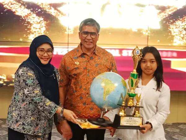 Pj Wali Kota Cimahi, Dicky Saromi bersama Kepala DP3AP2KB, Fitriani Manan saat Memberikan Piala pada Siswi Juara Sekolah Siaga Kependudukan (SSK) (mong)