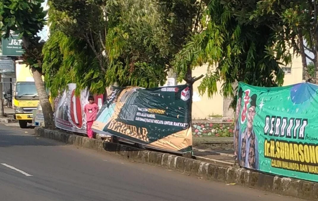 Beberapa Alat Peraga Kampanye (APK) yang diduga difasilitasi oleh KPU Banjar pernah dipasang di tempat yang dilarang, yakni di pohon samping jalan raya. (Cecep Herdi/Jabar Ekspres)