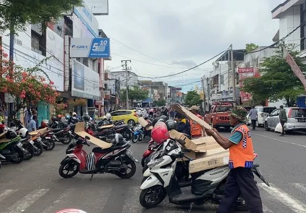 Juru Parkir di Jalan Letjen Soewarto Kota Banjar tengah merapihkan sepeda motor. Tarif retribusi parkir kendaraan masih sama sejak tahun 2016. (Cecep Herdi/Jabar Ekspres)