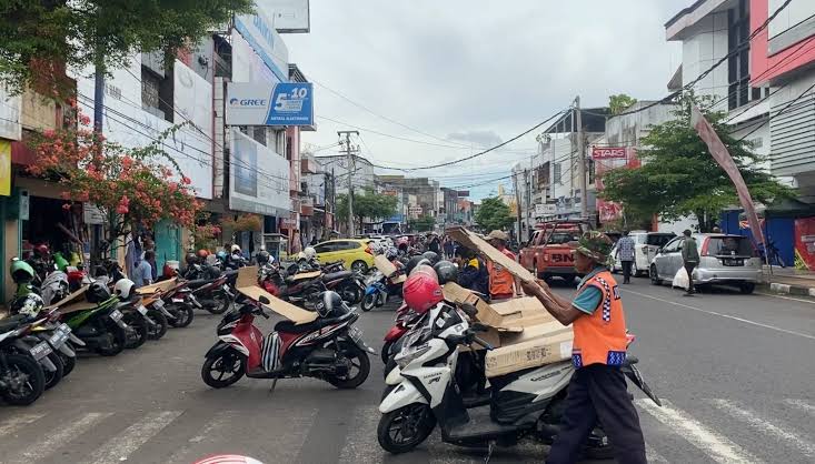 Juru Parkir di Jalan Letjen Soewarto Kota Banjar tengah merapihkan sepeda motor. Tarif retribusi parkir kendaraan masih sama sejak tahun 2016. (Cecep Herdi/Jabar Ekspres)