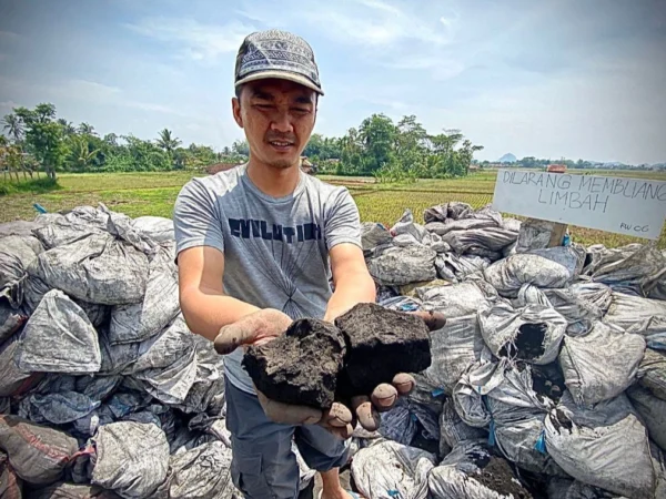 Salah satu warga saat memperlihatkan limbah hasil pembakaran batu bara di Jalan Irigasi, Kampung Rongga, Desa/Kecamatan Cihampelas. Dok Jabar Ekspres