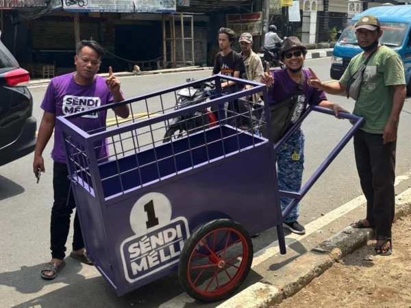 Perwakilan Tim Pemenangan pasangan calon Wali Kota dan Wakil Wali Kota Bogor, Sendi-Melli saat simbolisasi penyerahan bantuan Gerobak Sampah di sejumlah wilayah Kota Bogor. (Yudha Prananda / Jabar Ekspres)