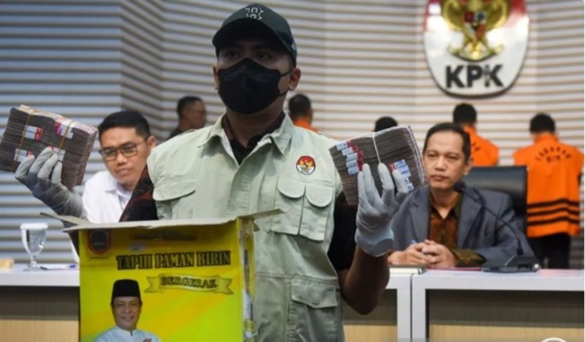 Petugas menunjukan barang bukti uang dan kardus bergambar Sahbirin Noor. (Foto/ANTARA)