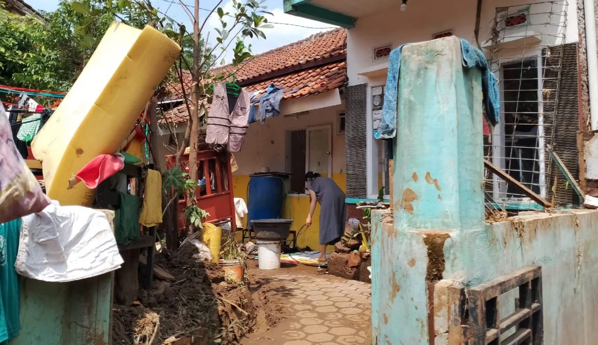 Warga saat membersihkan rumahnya akibat diterjang banjir di Kecamatan Banjaran, Kabupaten Bandung. (Agi / Jabar Ekspres)