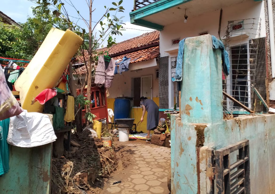 Warga saat membersihkan rumahnya akibat diterjang banjir di Kecamatan Banjaran, Kabupaten Bandung. (Agi / Jabar Ekspres)