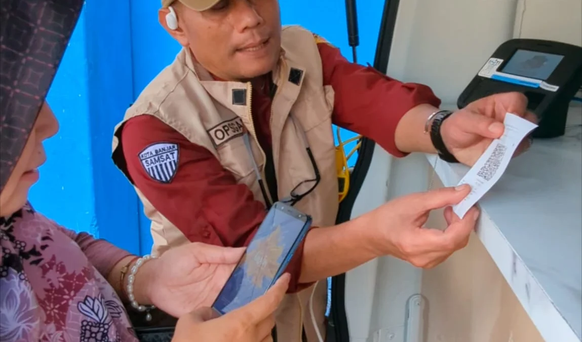 Petugas P3DW Kota Banjar memperlihatkan barcode pembayaran kepada salah satu wajib pajak kendaraan bermotor yang akan membayar pajak, Selasa 12 November 2024. (Cecep Herdi/Jabar Ekspres)